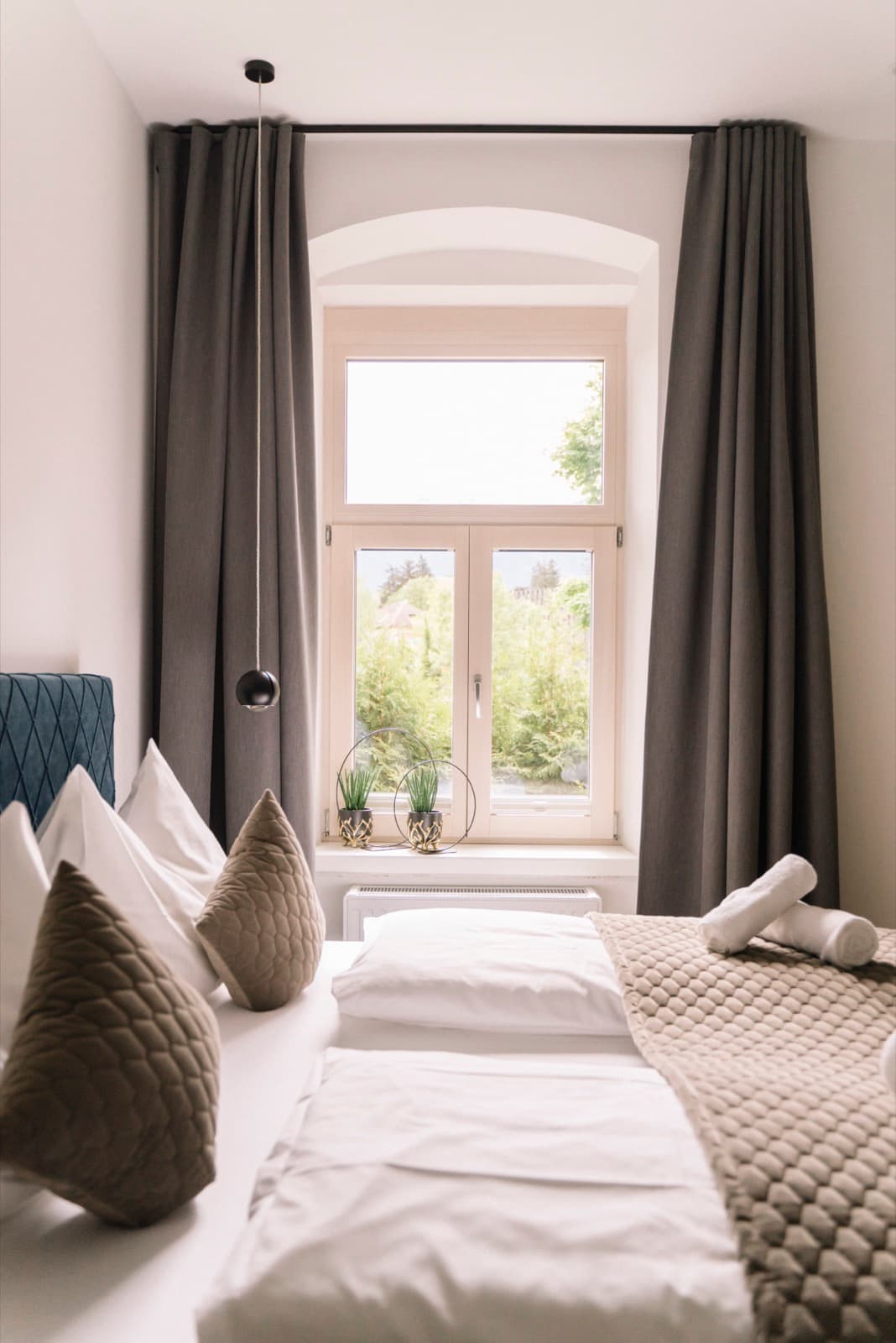Helles Schlafzimmer mit Rundbogenfenster in Innsbruck