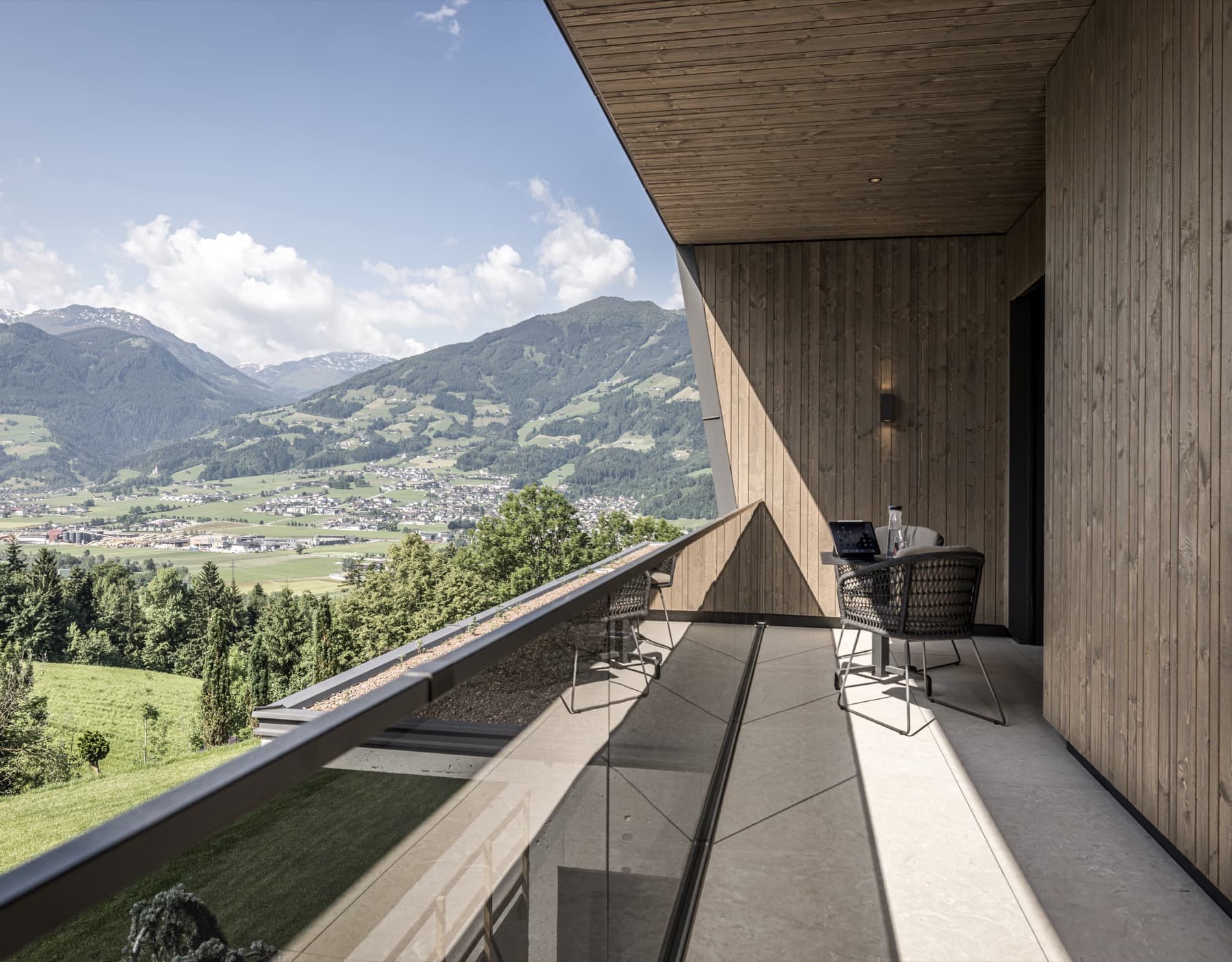 The spacious balcony of the Panorama Nature Lodge with seating and an open panoramic view of the Zillertal mountains.