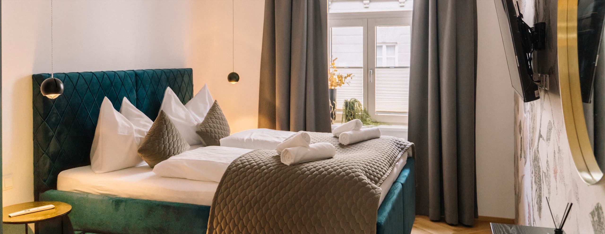 Schlafzimmer mit grünem Polsterbett und Rundbogenfenster in Innsbruck
